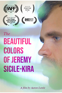 Film poster for the Beautiful Colors of Jeremy Sicile-Kira: closeup of a frowning man with a moustache and bread in profile.Light green blurs dot the foreground. Superimposed over the image are award laurels in black, the title of the film in pink and purple bold text, and the words A Film By Aaron Lemle in purple italics.