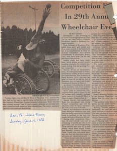 Newspaper clipping of an article titled 29th Annual Wheelchair Event. In the photo, a muscular male shot-putter in a wheelchair twists to one side and reaches one arm over his head, heaving an iron ball into the air. 