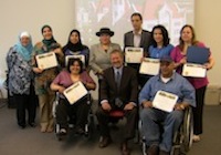 A large group of training attendees display their completion certificates.