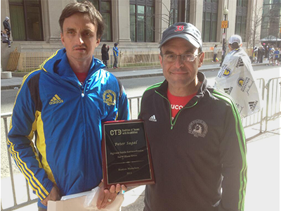 Two men pose with a plaque.